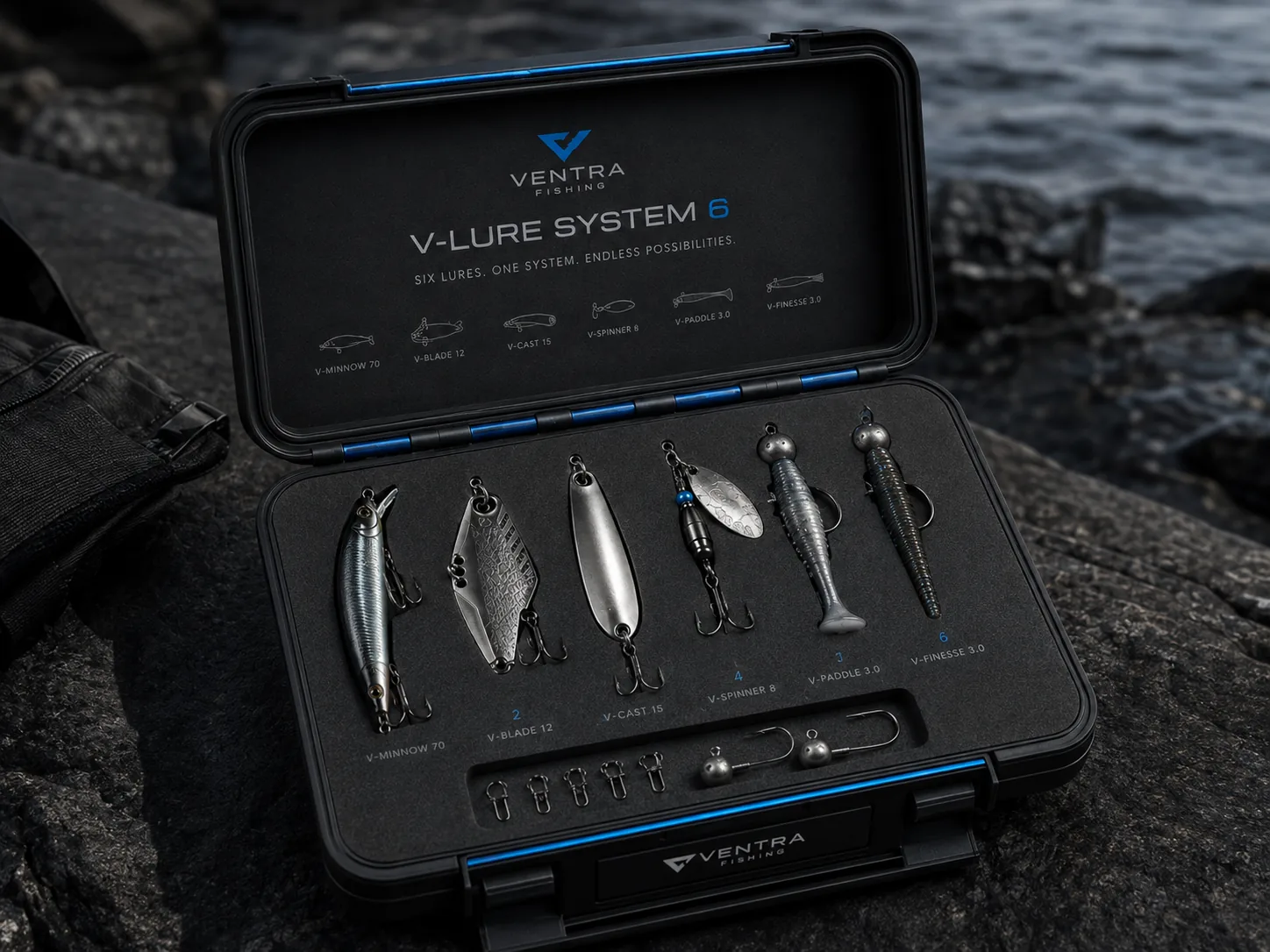 The V-Lure System 6 hard case open on wet rock beside the water, six lures and terminal tackle in the foam